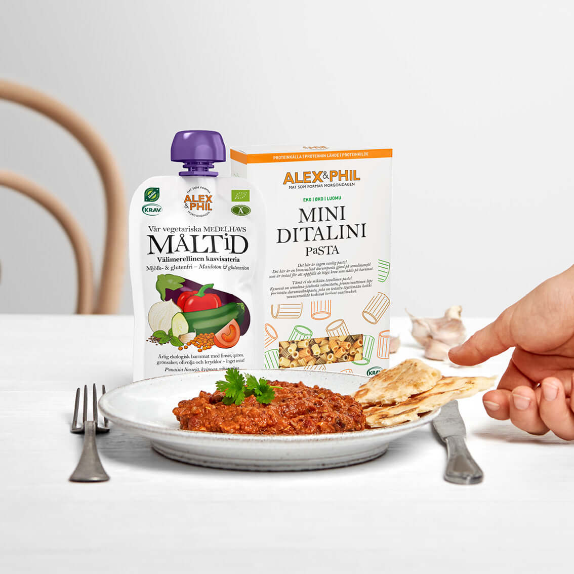 En person håller en tallrik med en skål med alexphilfood Pasta Mini Ditalini, som är proteinrik.